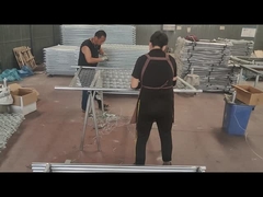 İşçiler zincir bağlantı çitini ve çerçeve borusunu bağlamak için tel kullanıyor